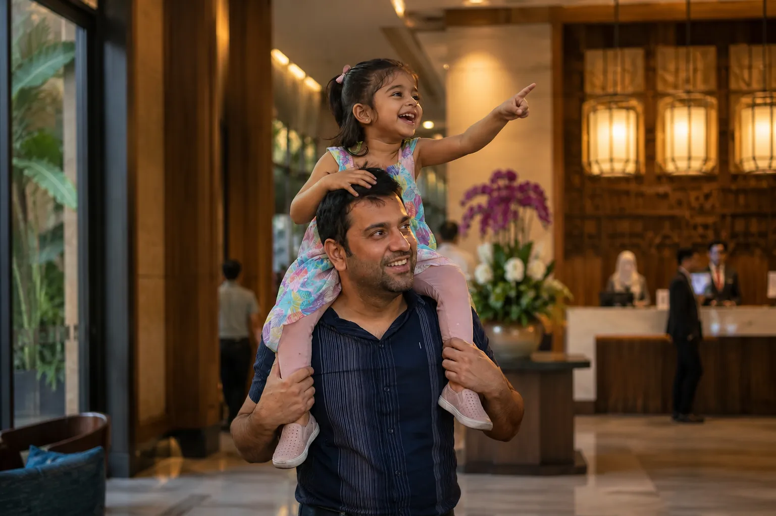 South Asian father and daughter laughing in Bangkok halal hotel lobby