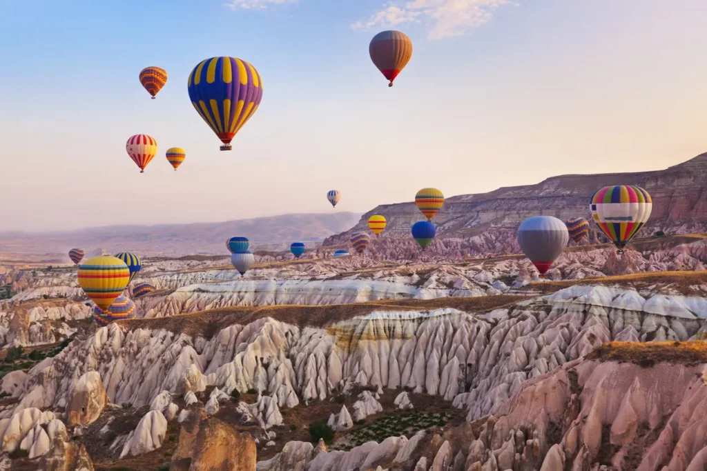 Hot air balloons over Cappadocia rock valleys — Turkey wellness retreat slow travel
