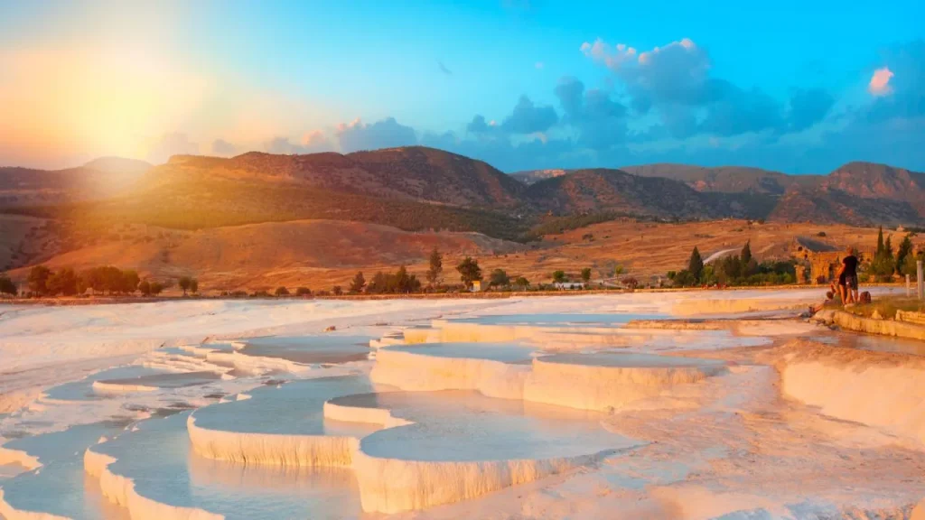 Pamukkale travertine terraces at golden sunset with Anatolian hills where to stay for Pamukkale trip