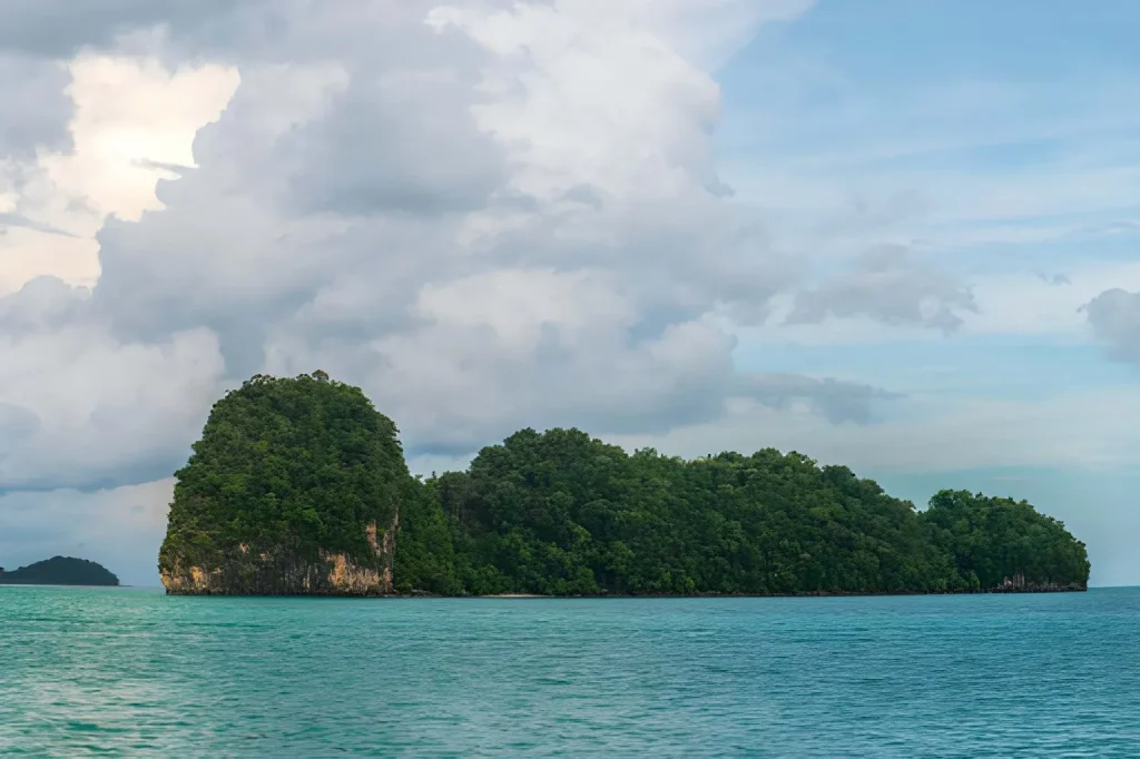 Lush green limestone island rising from Langkawi's turquoise sea Malaysia family trip
