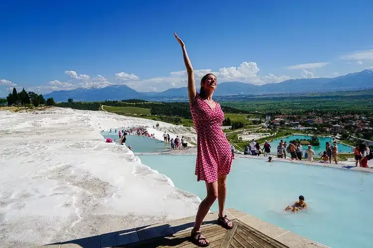 Woman at Pamukkale thermal terraces Turkey wellness retreat amid white calcium pools

