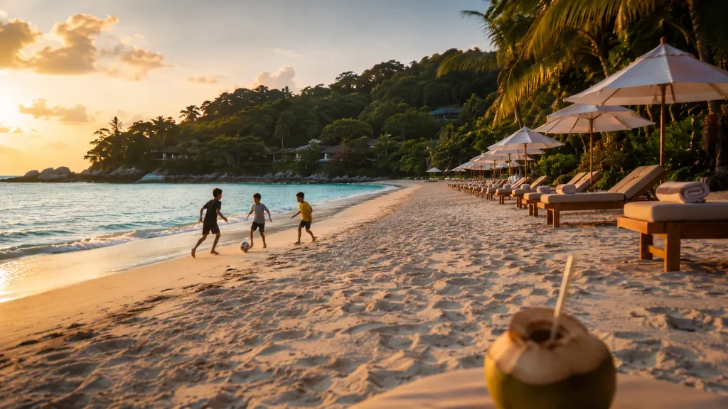 Pristine white sand beach in Phuket with turquoise water, sunbeds, and distant family silhouettes at golden hour | Thailand Wellness Retreats