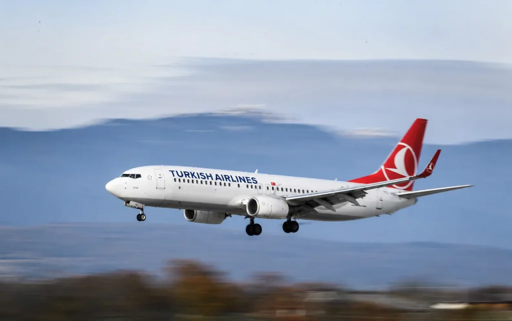 Turkish Airlines Boeing 737 landing with blue sea backdrop, Turkey wellness retreats flight from Pakistan