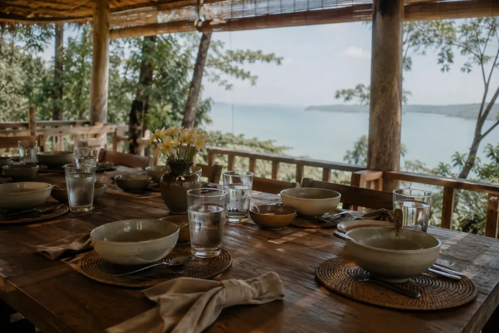 Communal dining terrace at a Thailand wellness retreat overlooking the sea