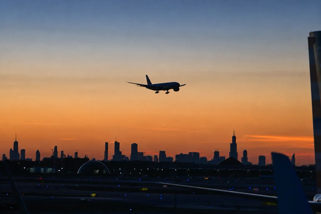 Aircraft descending at dusk over a Gulf hub skyline, the required stopover on the way to the Maldives.