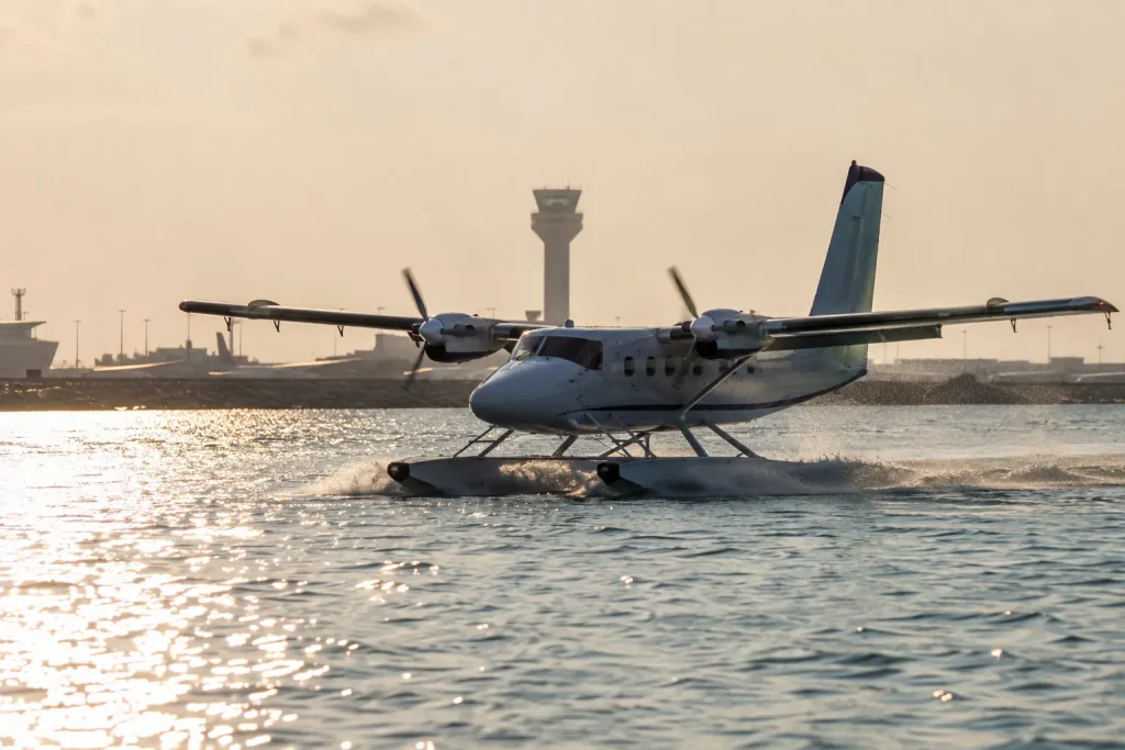 Seaplane skimming across the water at golden hour, illustrating the 3:30 PM transfer cutoff for Maldives resort arrivals.