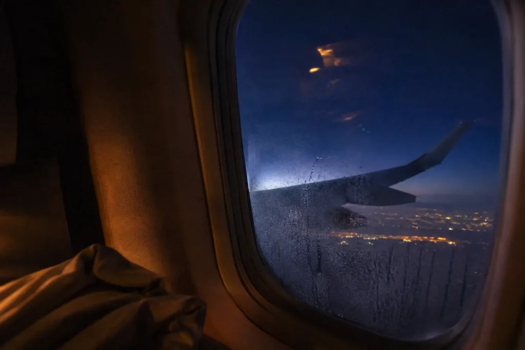 Night flight window view en route from Karachi to Bangkok for a Thailand retreat
