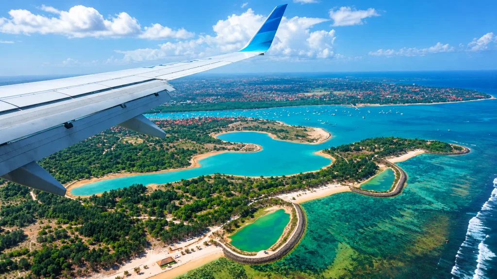 Aircraft wing over Bali's coastline on approach to Denpasar, where entry requirements are now checked closely
