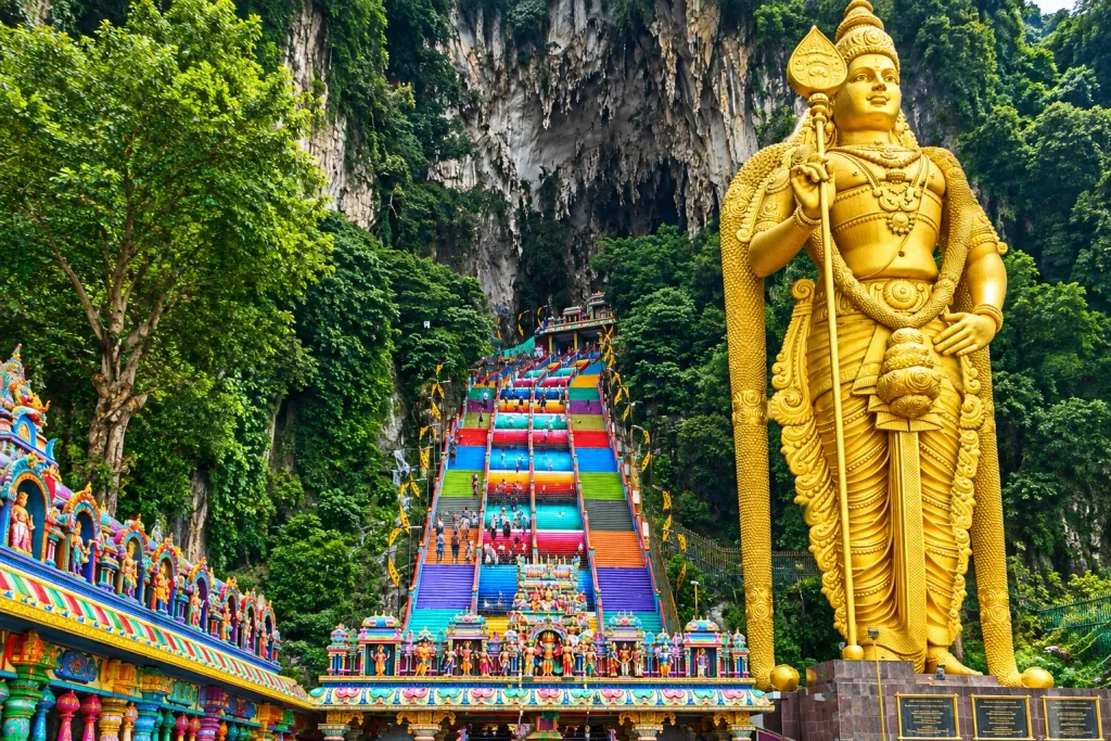 The golden Murugan statue and rainbow steps at Batu Caves, a top solo Kuala Lumpur trip day-trip destination.