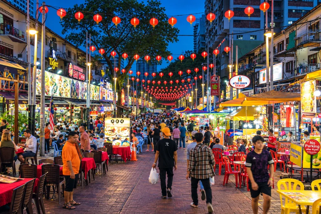 Lantern-lit food stalls and diners along Jalan Alor, Kuala Lumpur's night market street for solo travelers.