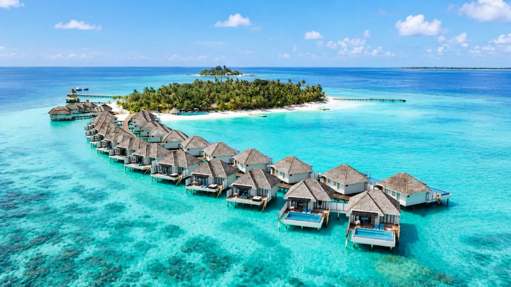 Aerial view of overwater villas with plunge pools on a turquoise Maldives lagoon