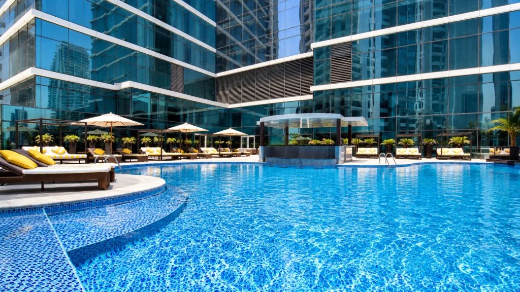 Hotel pool framed by glass towers in Dubai, the kind of four-star stay discounted for this year's Dubai winter break