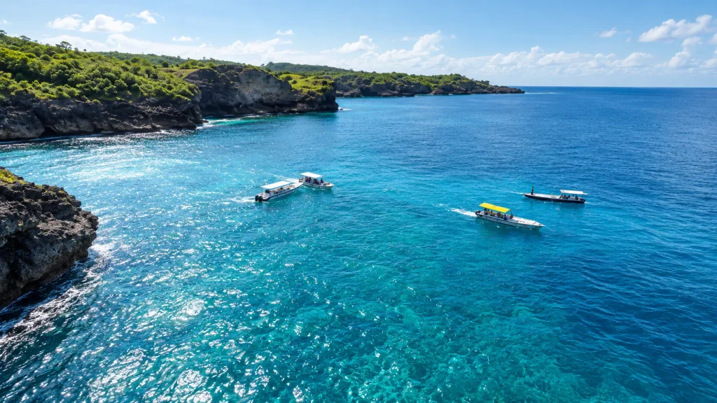 Dive and snorkel boats on turquoise water beside green limestone cliffs, boat hire for a Menjangan Island day trip
