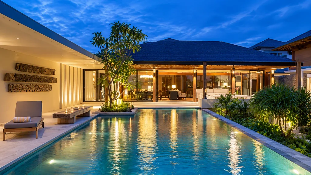 Bali Christmas villa at twilight with a lit private pool and open-plan living area 