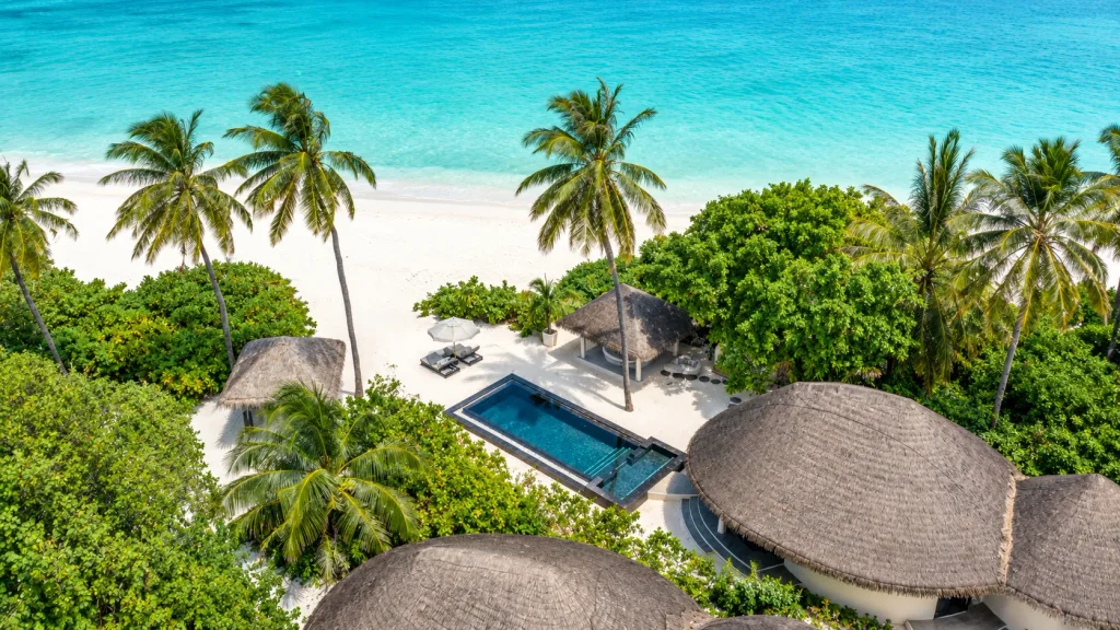 Private pool villa hidden among palms on a white-sand Maldives beach, suited to Muslim families